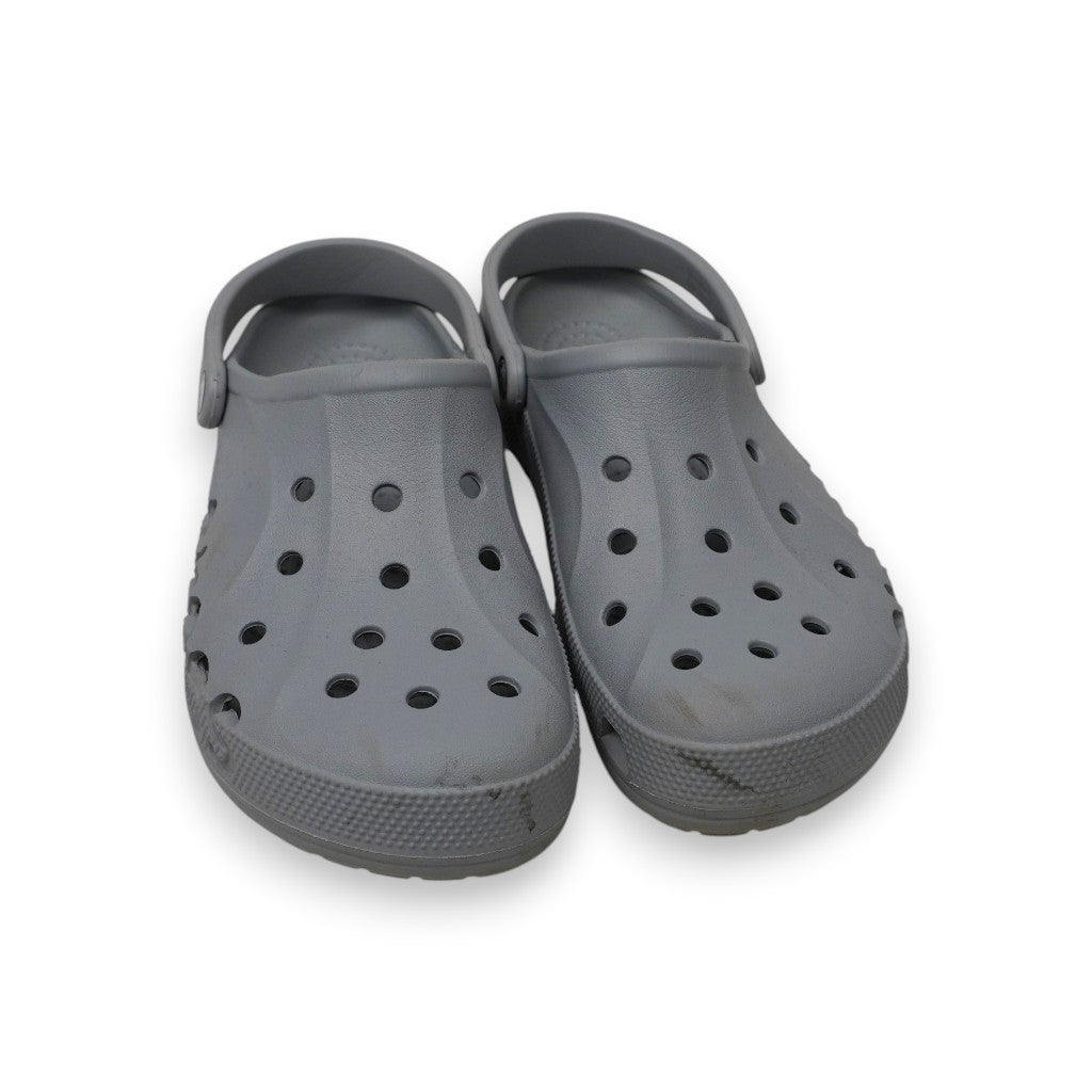  Inquadratura dall'alto a tre quarti delle ciabatte Crocs Baya Clog grigie poggiate su sfondo bianco, che mostra il design sportivo.