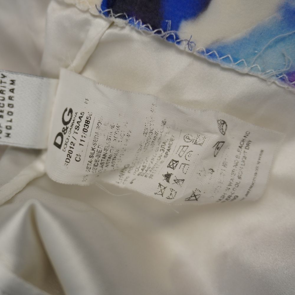 Dettaglio macro del tessuto in seta dell'abito D&G con una leggera sbavatura rosa sfumata vicino alla cucitura