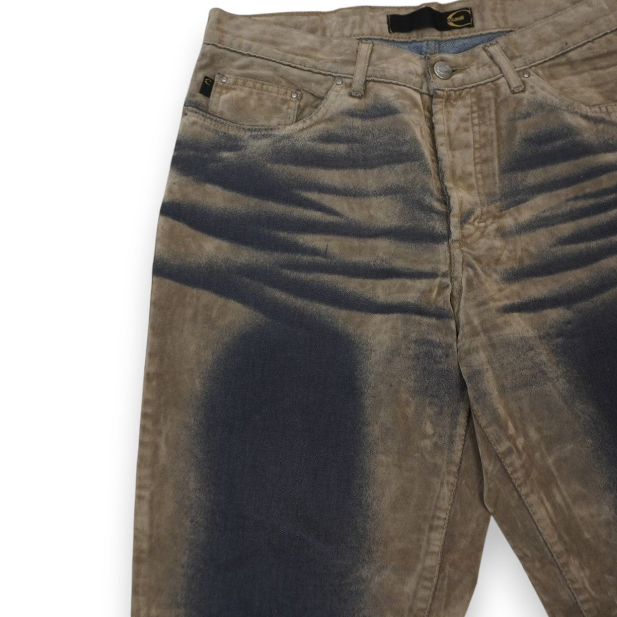Primo piano del bacino dei jeans Just Cavalli che mostra profonde baffature tridimensionali e sfumature scure ad aerografo su base tortora.
