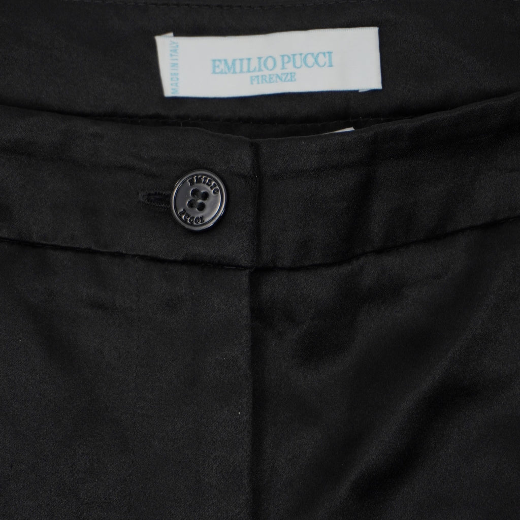 Primo piano della chiusura frontale con bottone e patta sartoriale dei pantaloncini neri Emilio Pucci.