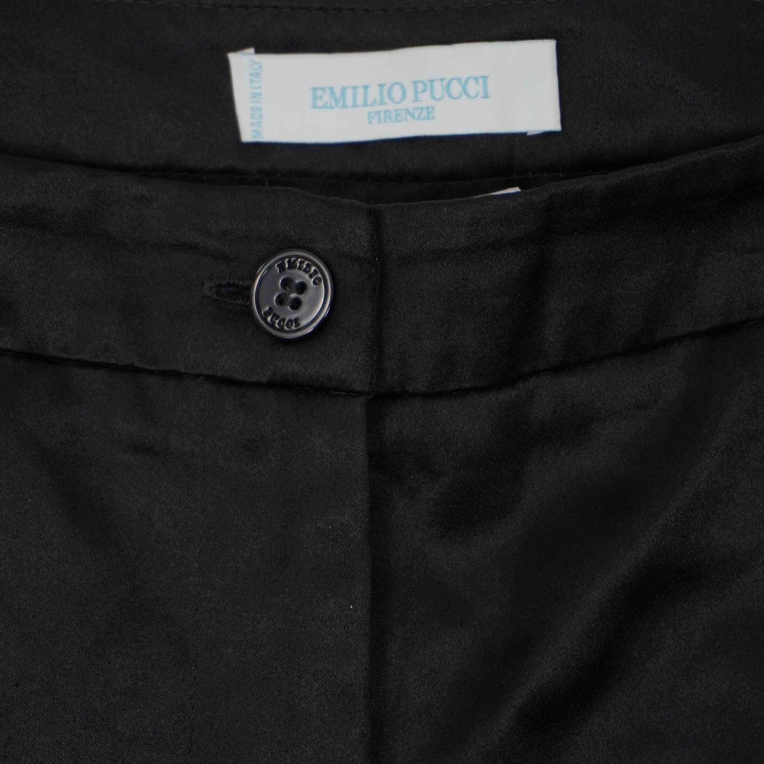 Primo piano della chiusura frontale con bottone e patta sartoriale dei pantaloncini neri Emilio Pucci.