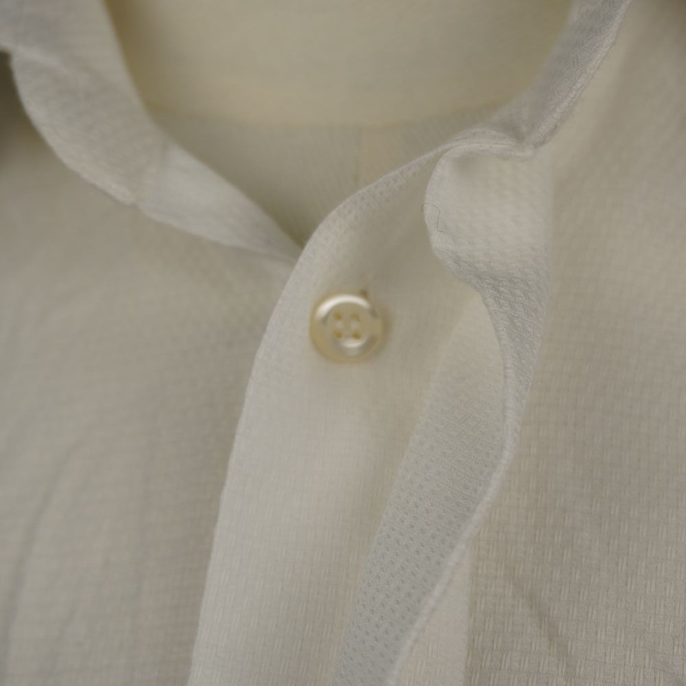 Macro sul primo bottone in madreperla e sull'apertura del colletto della camicia da uomo vintage Dior.