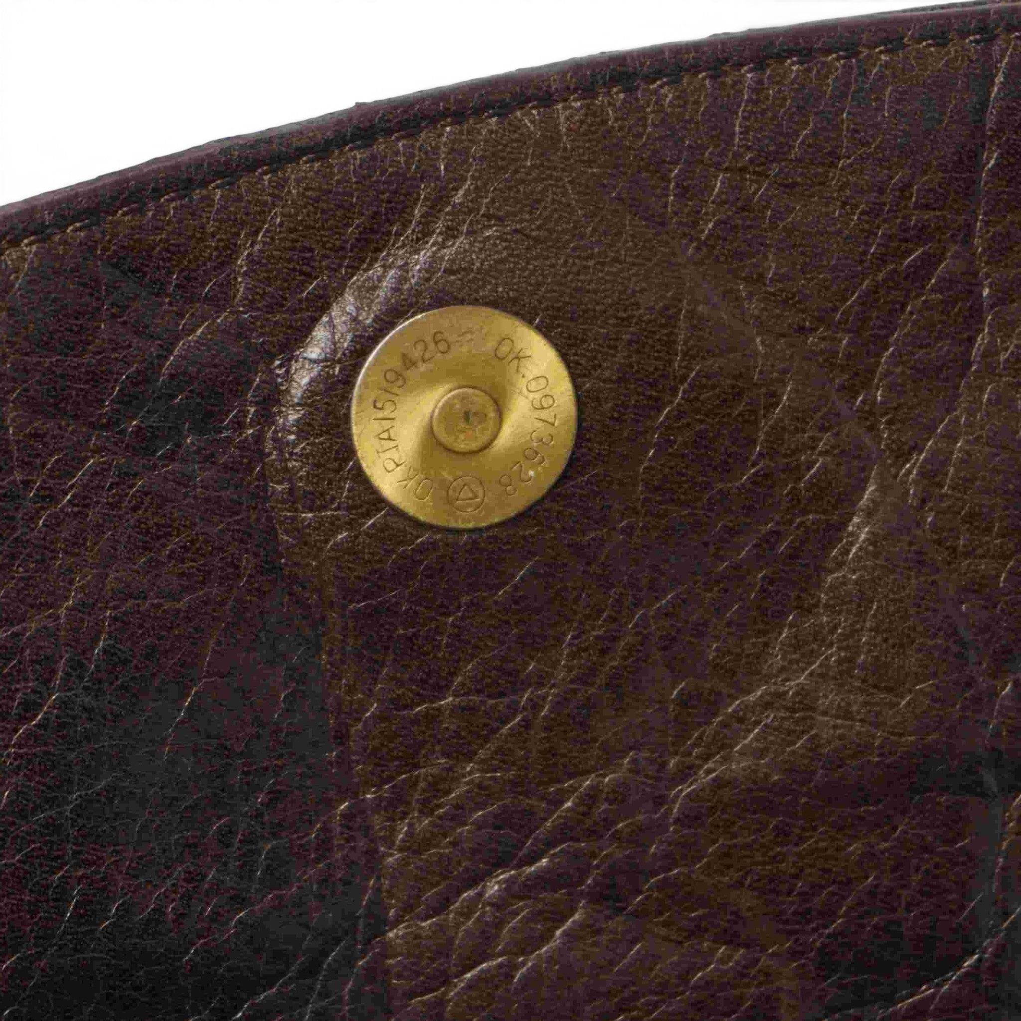 Inquadratura ravvicinata del bottone automatico magnetico interno per la chiusura della borsa.