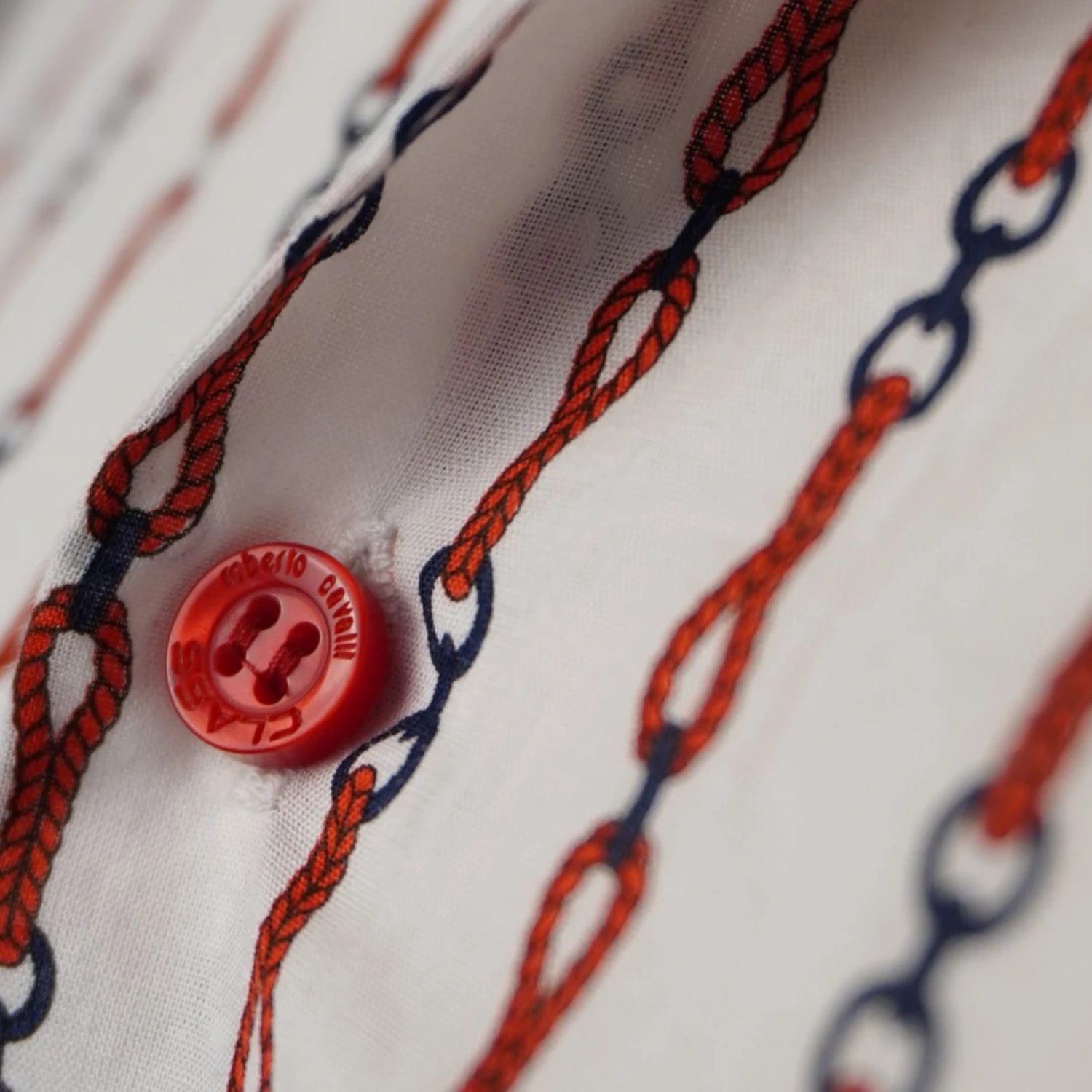 Dettaglio macro bottone rosso personalizzato con logo inciso Class Roberto Cavalli