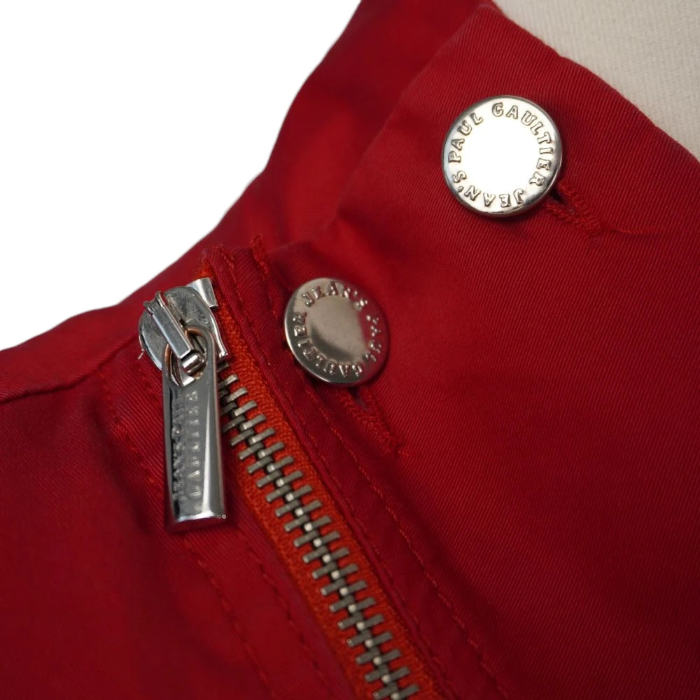 Primo piano dei bottoni a pressione metallici e della cerniera diagonale della giacca Jean Paul Gaultier.