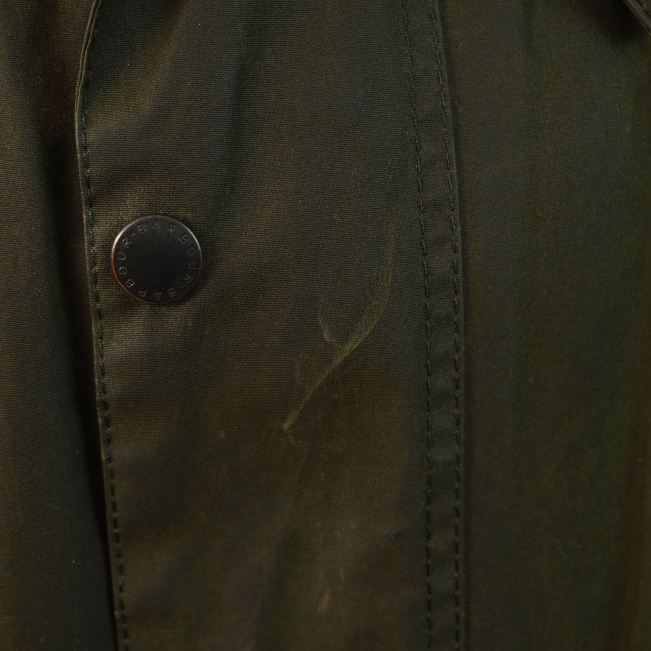 Particolare dei bottoni a pressione logati sulla patta protettiva antivento della giacca Barbour Beaufort.
