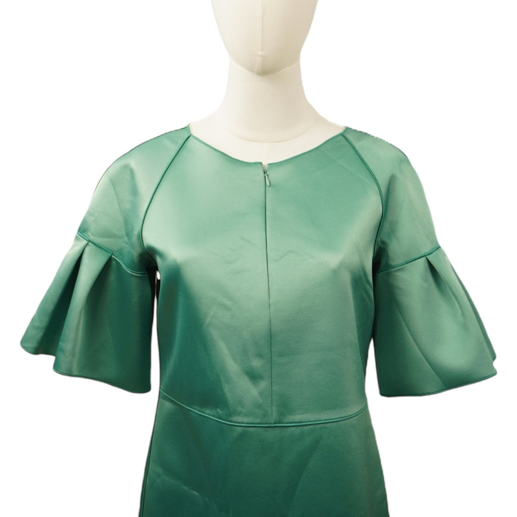 Primo piano del busto e della scollatura rotonda dell'abito verde satinato indossato dal manichino.