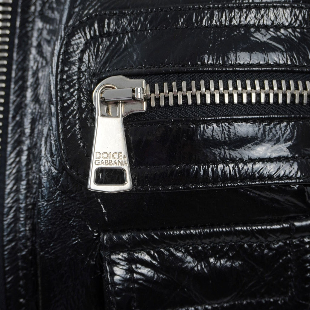 Inquadratura ravvicinata del cursore in metallo argentato lucido inciso con il logo ufficiale del brand Dolce & Gabbana.