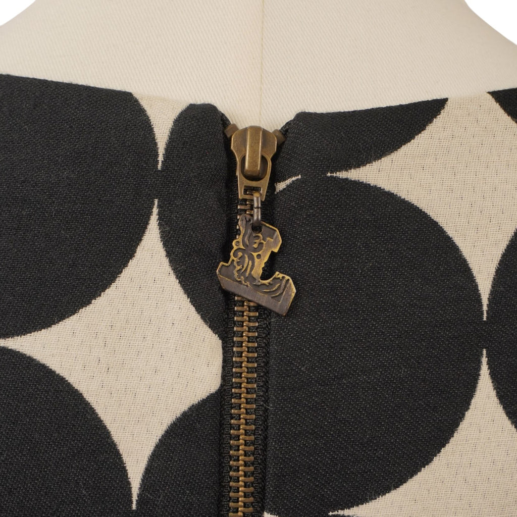 Primo piano della chiusura lampo metallica sul retro dello scollo con cursore personalizzato e sagomato.