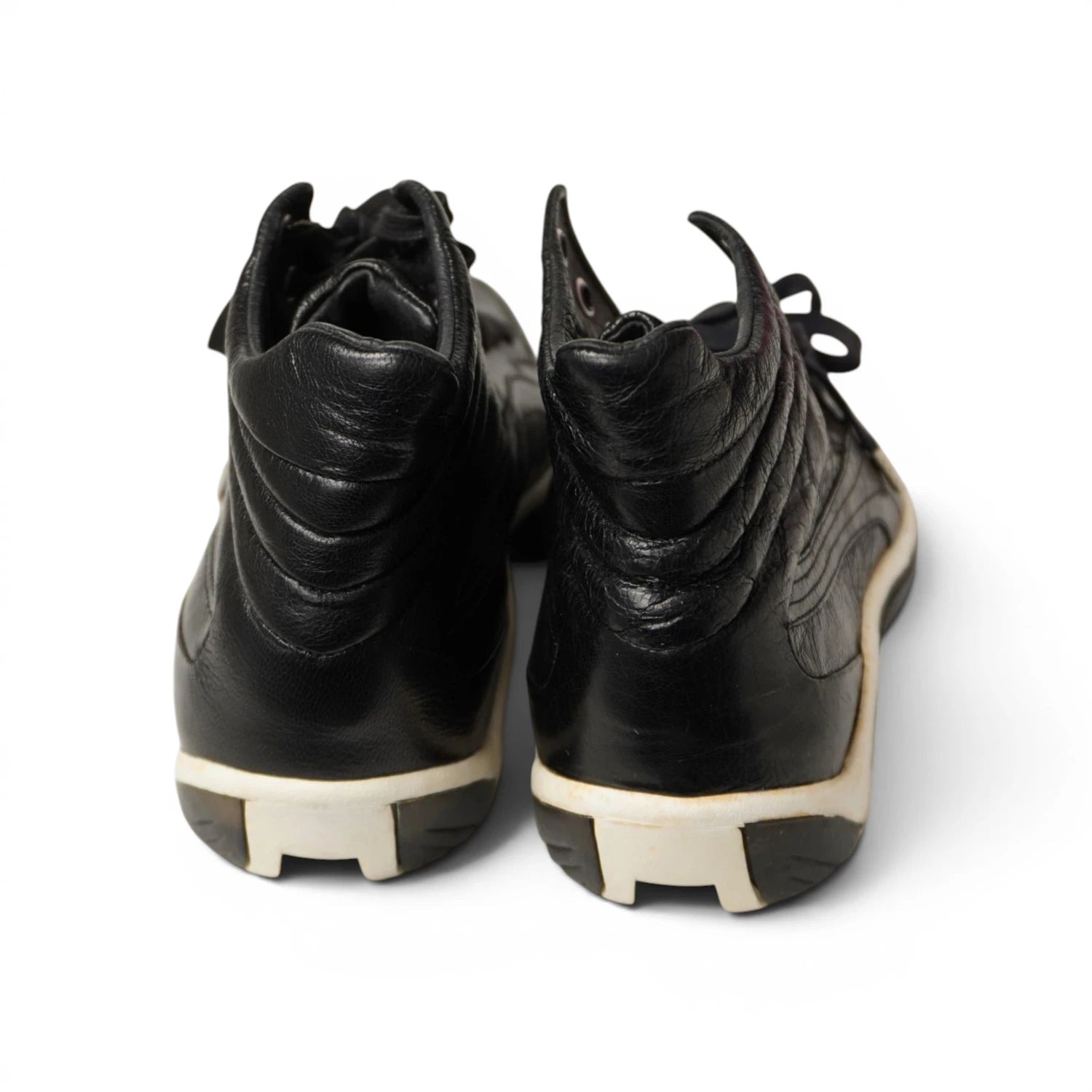 Dettaglio ciondolo metallico originale a forma di artiglio e colletto trapuntato su sneaker Puma x Alexander McQueen