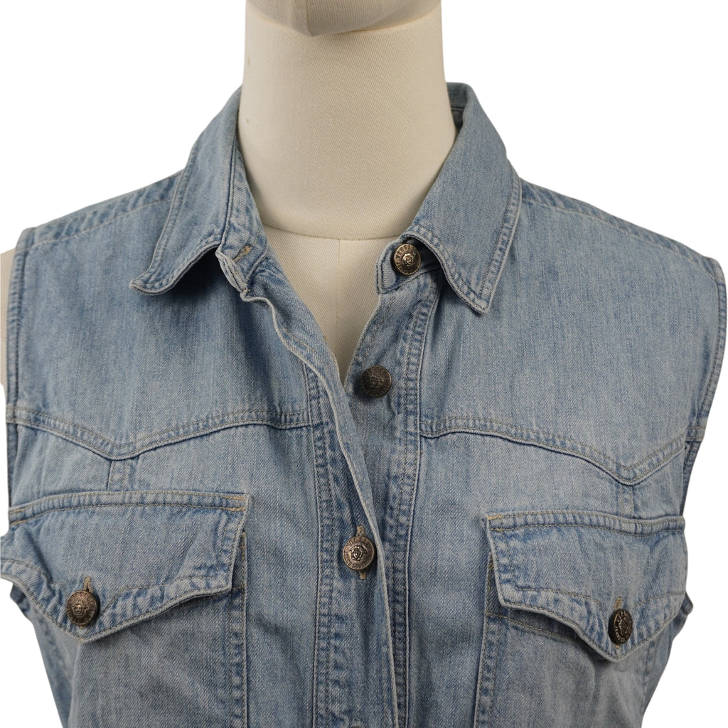 Primo piano del colletto classico a camicia e dei taschini anteriori del gilet Versace Jeans Couture con bottoni metallici logati.