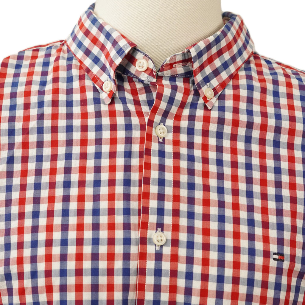Dettaglio ravvicinato del colletto classico a punta modello button-down abbottonato di una camicia a quadri.