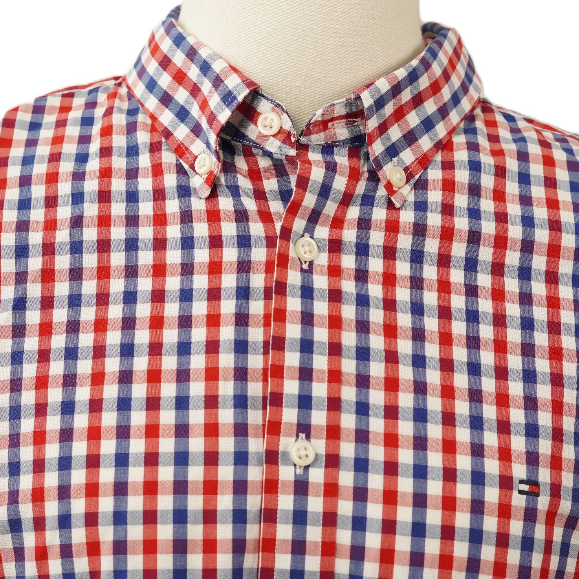 Dettaglio ravvicinato del colletto classico a punta modello button-down abbottonato di una camicia a quadri.