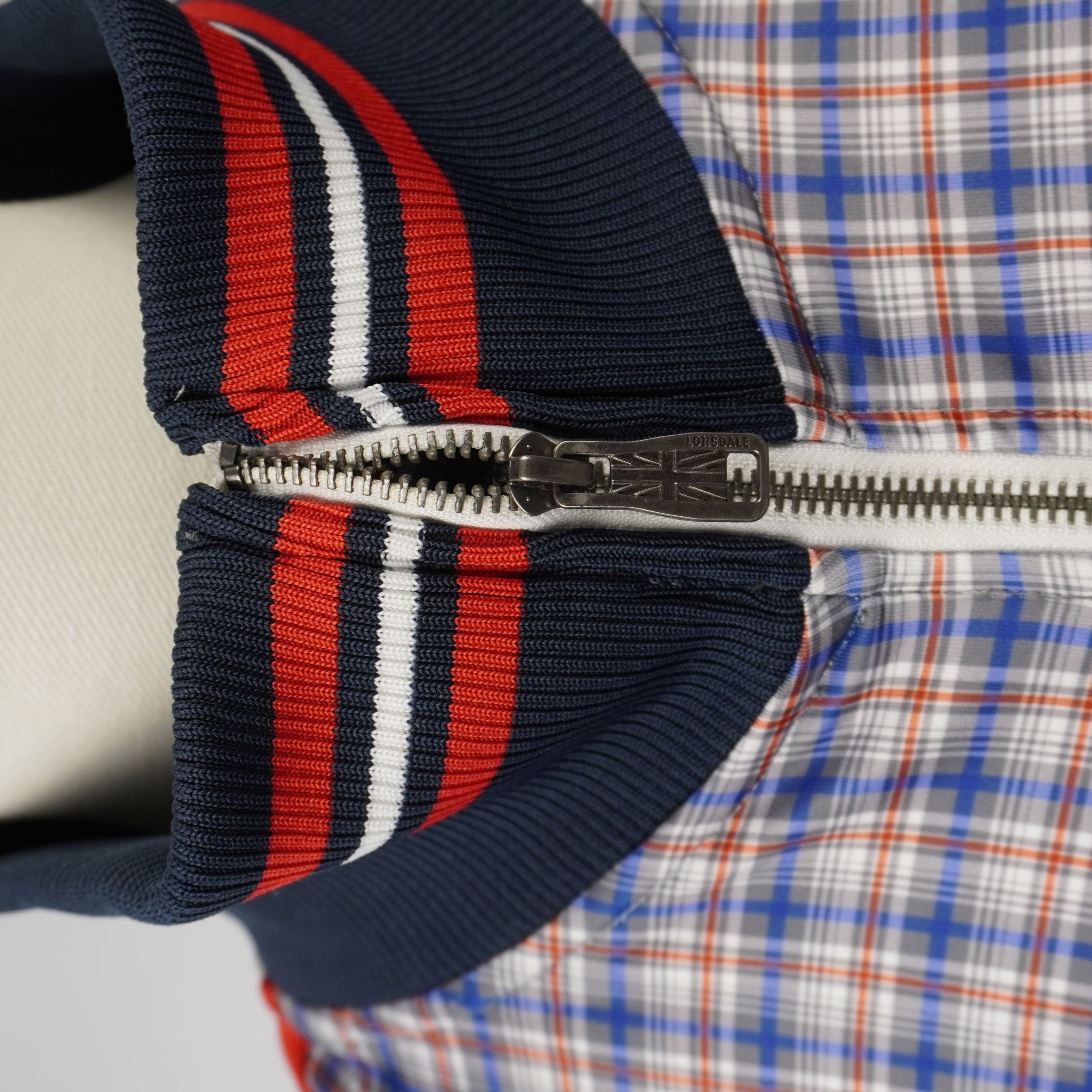 Dettaglio colletto a coste e cursore zip in metallo inciso Lonsdale Union Jack