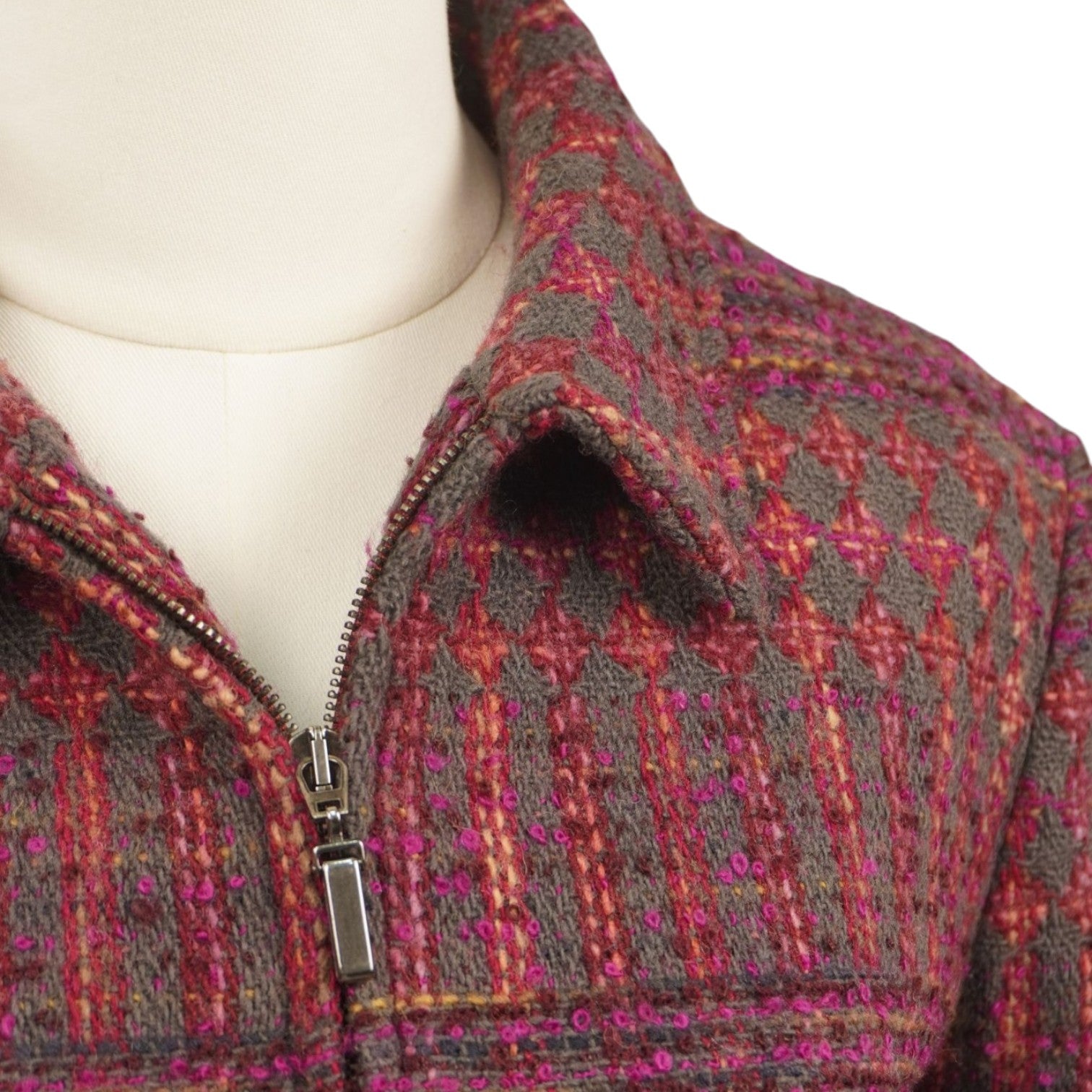 Primo piano del colletto classico e della chiusura lampo della giacca in maglia bouclé bordeaux.