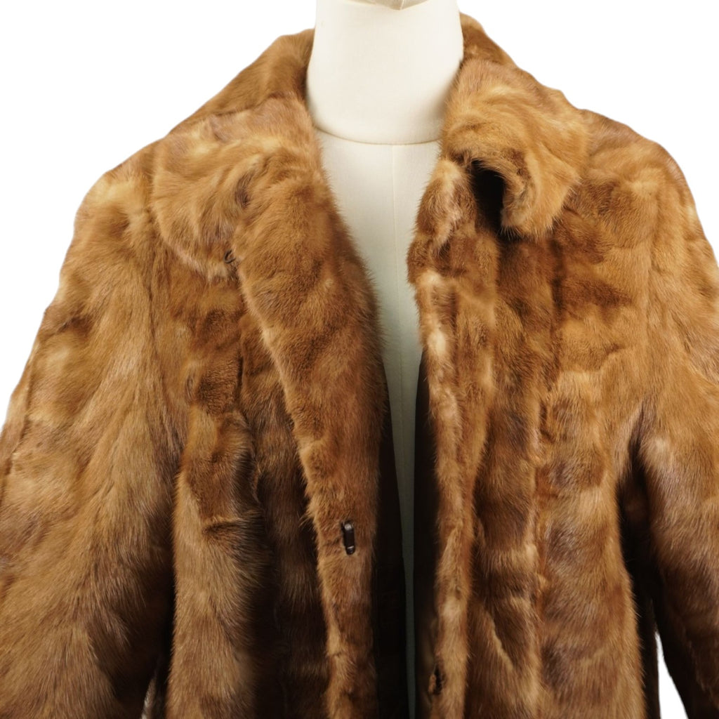 Primo piano della parte superiore del cappotto in visone con focus sul colletto classico e sulle spalle.