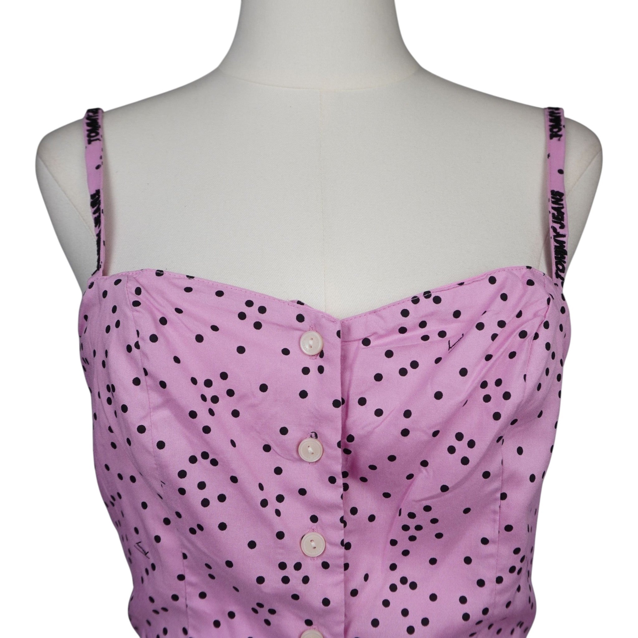 Dettaglio frontale del corpetto rosa stile bustier con scollo a cuore e bottoni chiari.