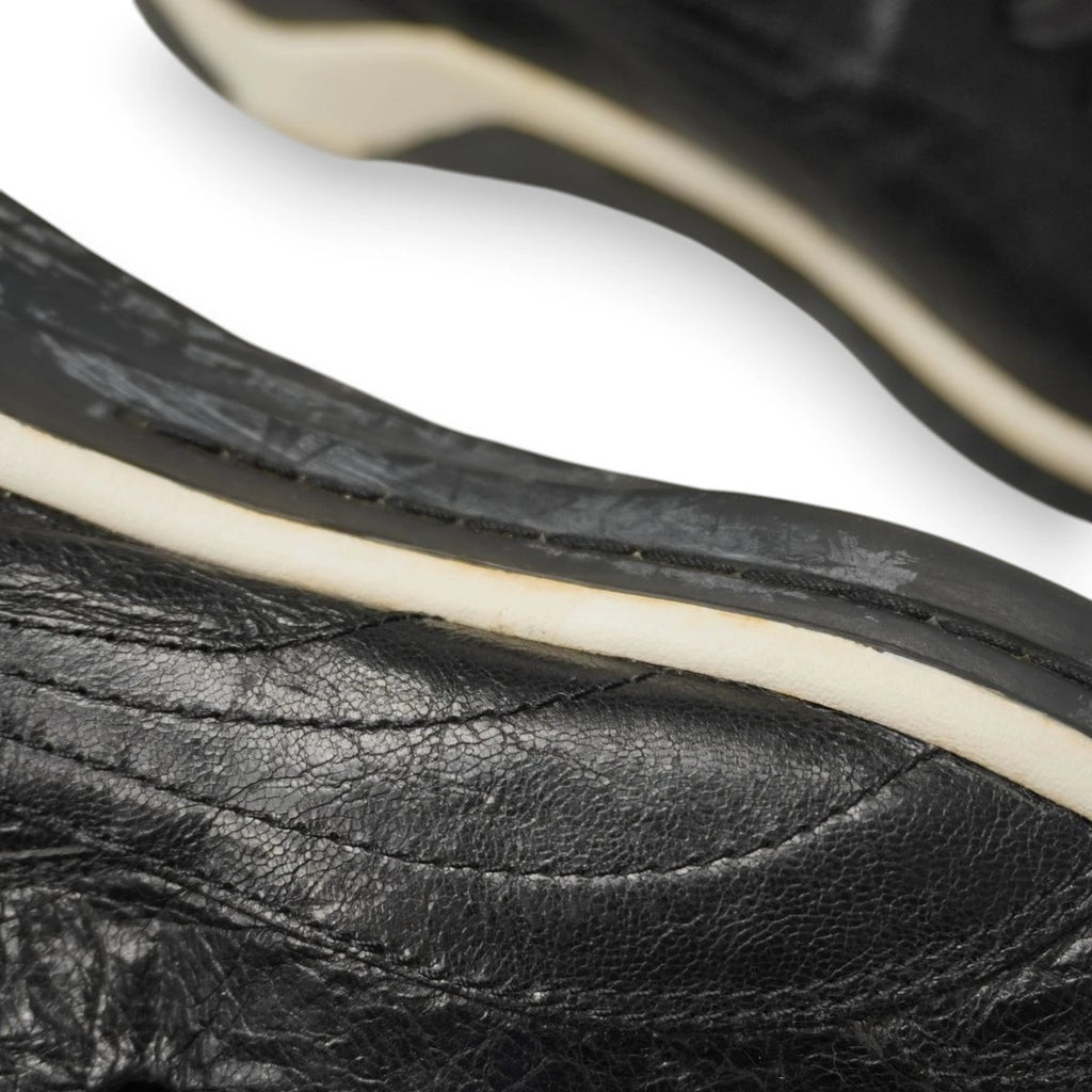 Macro pannello in pelle nera e cucitura perimetrale della suola sneaker Puma x Alexander McQueen