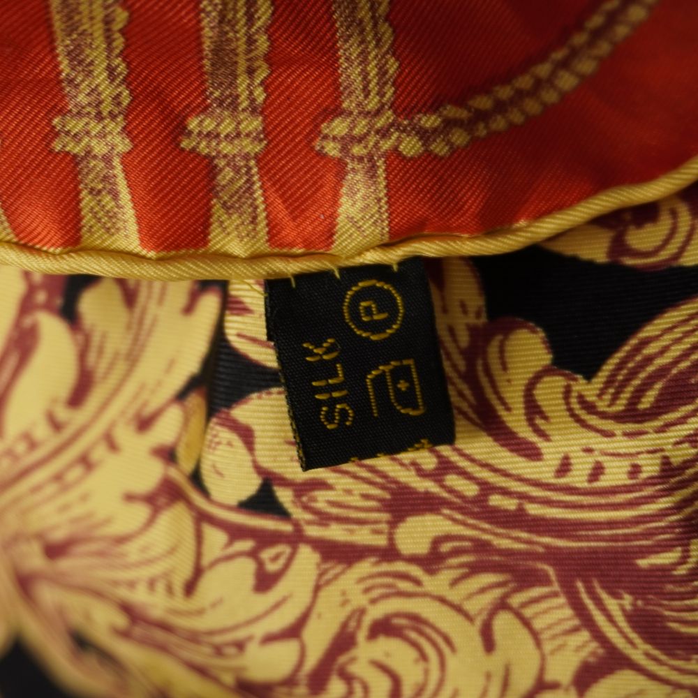 Foto macro del piccolissimo punto scuro millimetrico sulla seta arancione del foulard