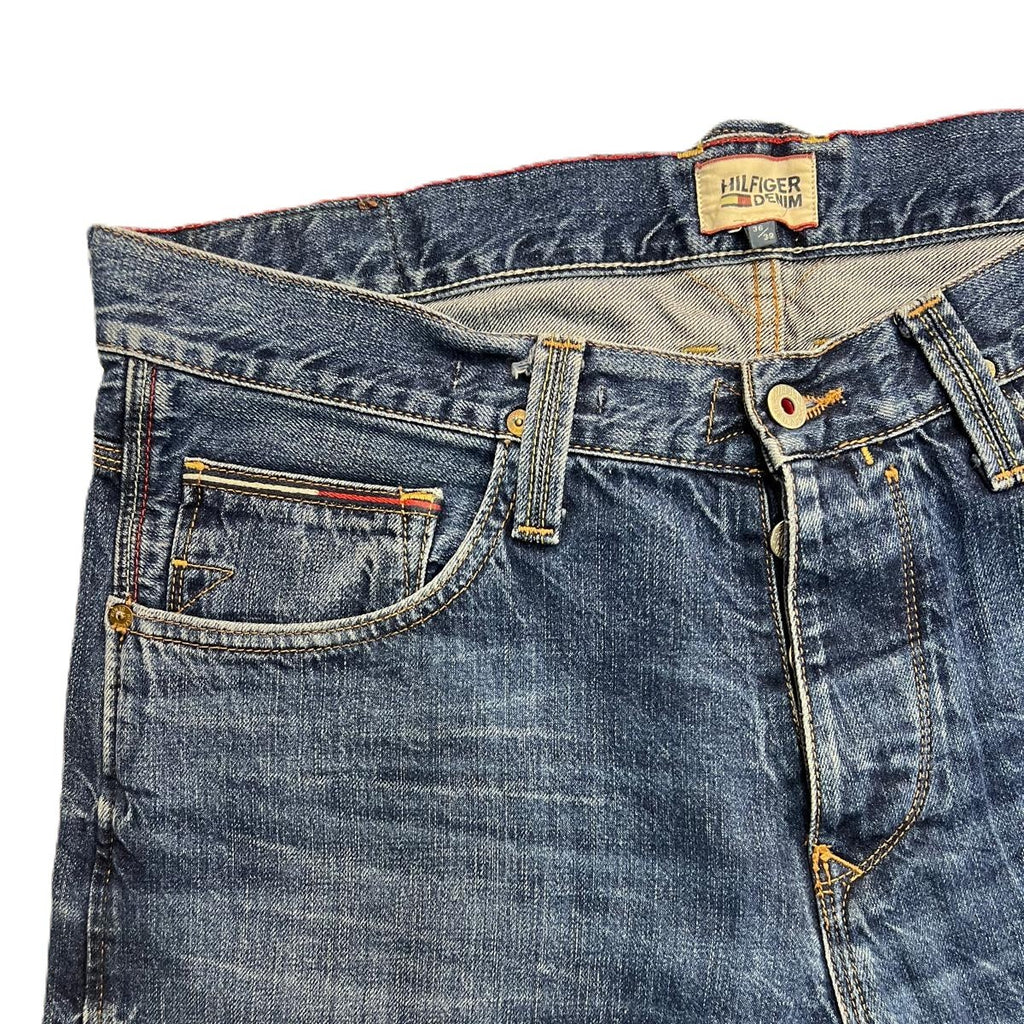 Vista ravvicinata della parte superiore frontale dei jeans con focus sul lavaggio indaco e sulle tasche.