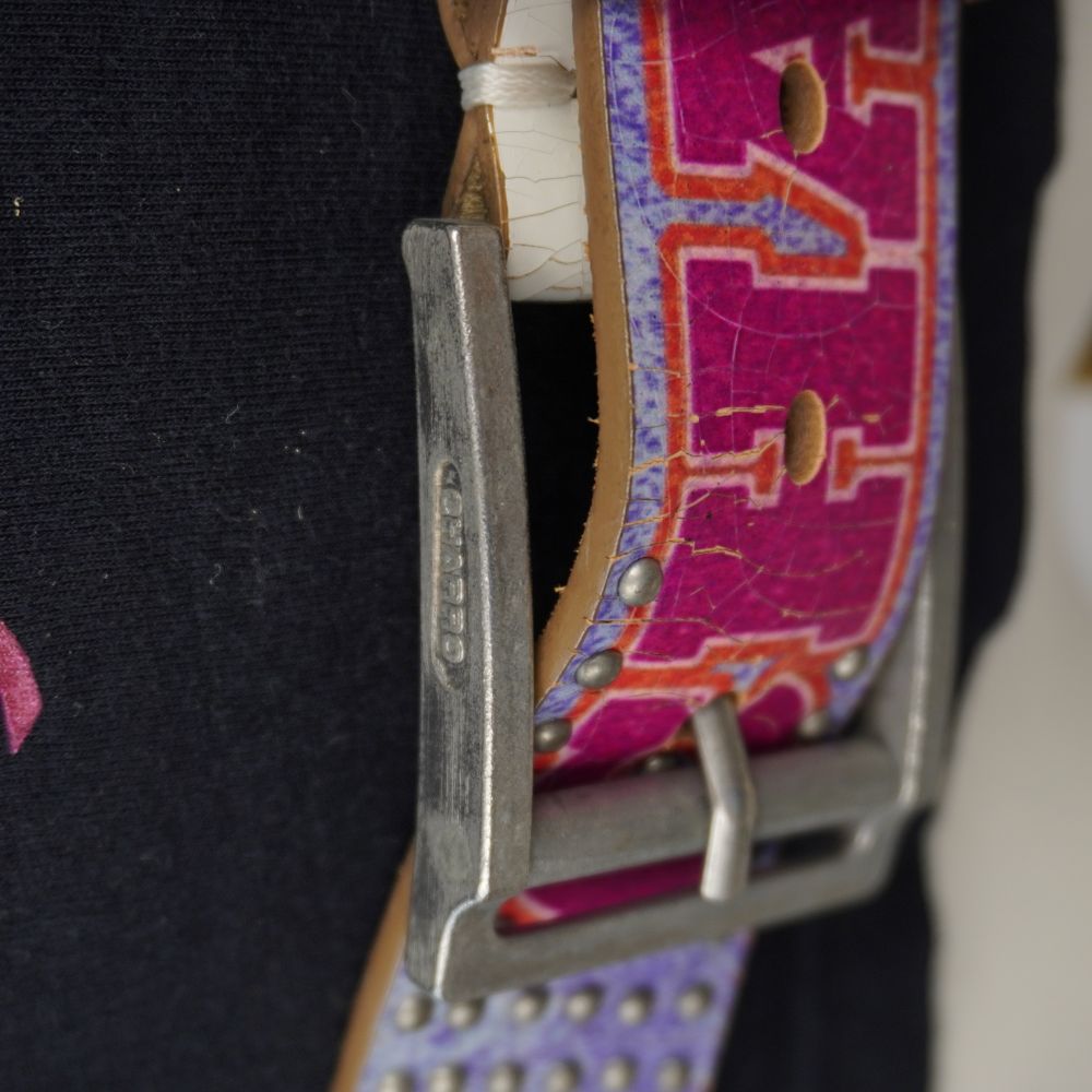 Inquadratura ravvicinata del passante della fibbia con incisione El Charro e inizio della stampa monogramma fucsia