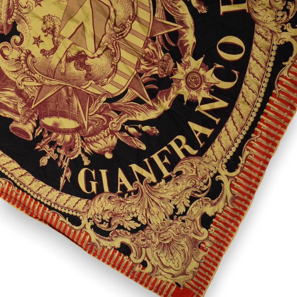 Primo piano della firma Gianfranco Ferré in lettere dorate su seta araldica nera
