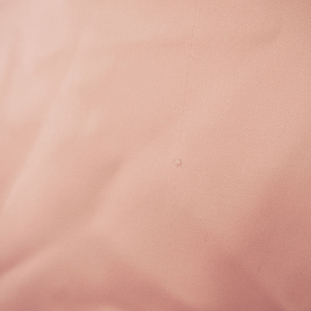 Macro della superficie liscia e lucida della fodera interna in tessuto satinato rosa cipria del bomber.