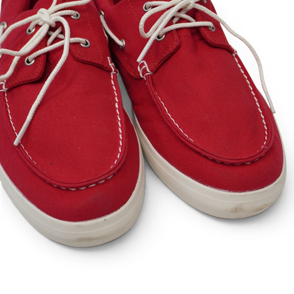 Dettaglio ravvicinato della parte anteriore delle scarpe da barca rosse con focus sui lacci bianchi intrecciati