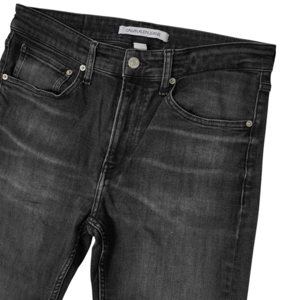 Dettaglio superiore frontale di jeans grigio scuro Calvin Klein con bottone metallico logato e taschino portamonete