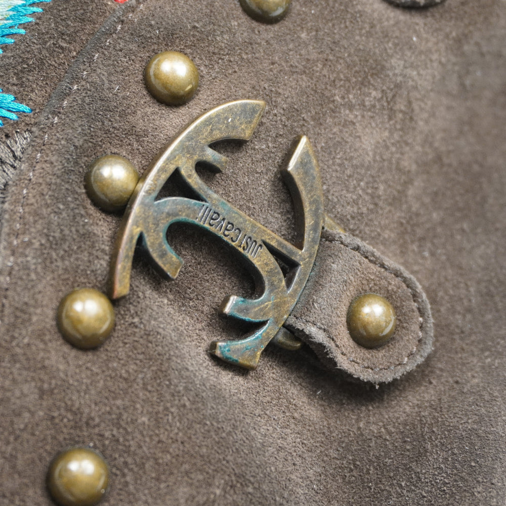 Macro della fibbia metallica dorata e brunita con incisione del logo Just Cavalli sulla borsa vintage in pelle scamosciata.