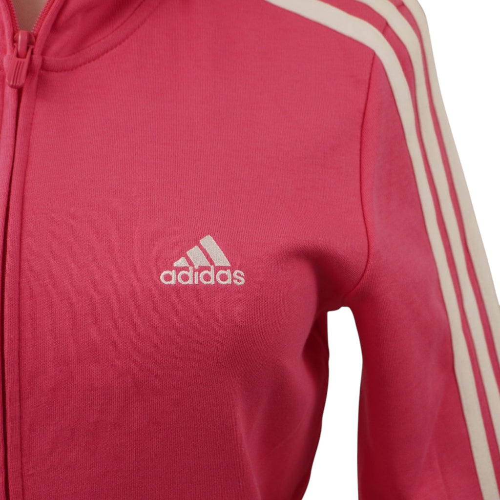 Primo piano del classico logo Adidas ricamato in filo bianco sul petto del tessuto rosa.