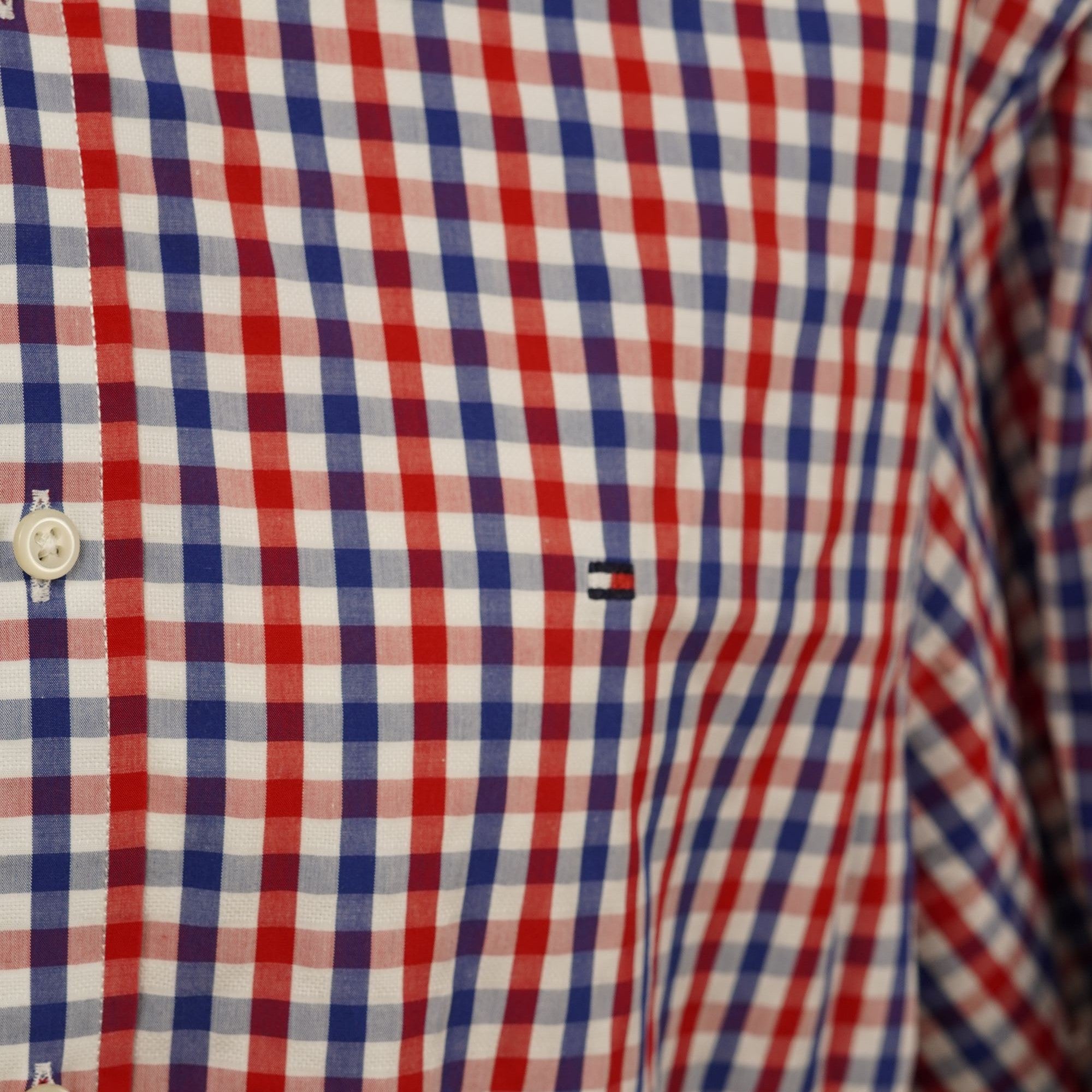 Primo piano del taschino o del petto della camicia con l'iconico micro logo a bandierina ricamato Tommy Hilfiger.