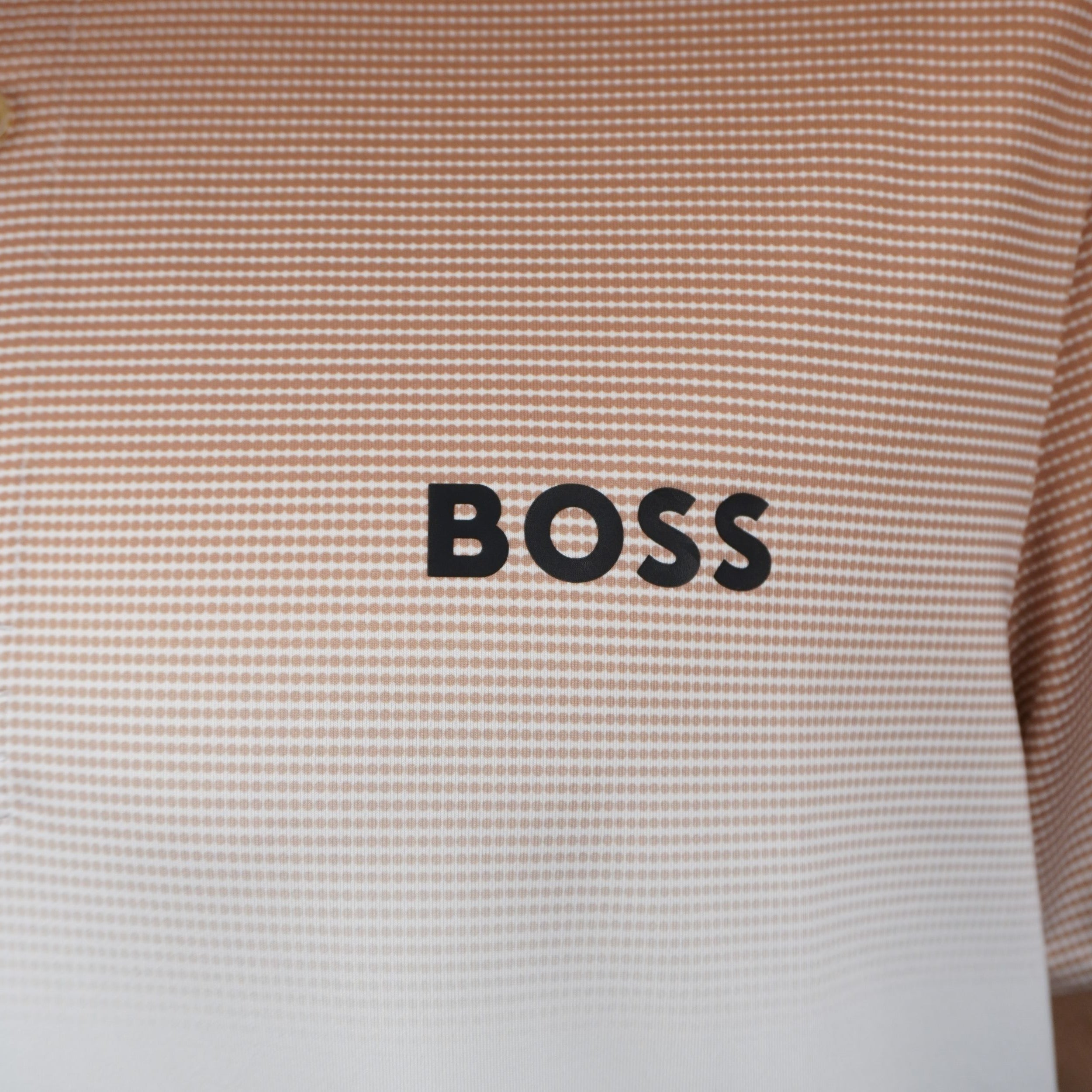 Primo piano del logo nero BOSS termoapplicato sul petto e della trama a micro-righe della polo tecnica Berrettini.