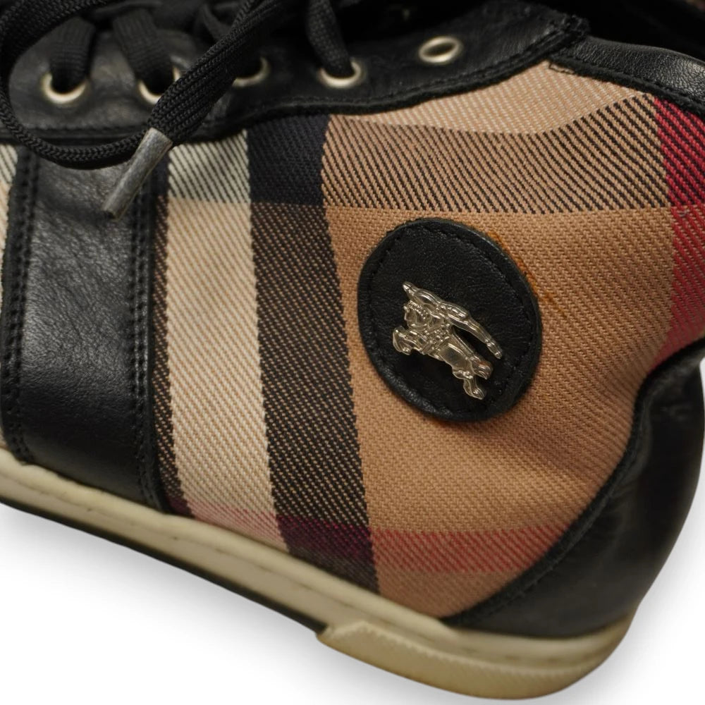 Primo piano dello stemma in pelle con il Cavaliere Prorsum metallico su sneakers Burberry