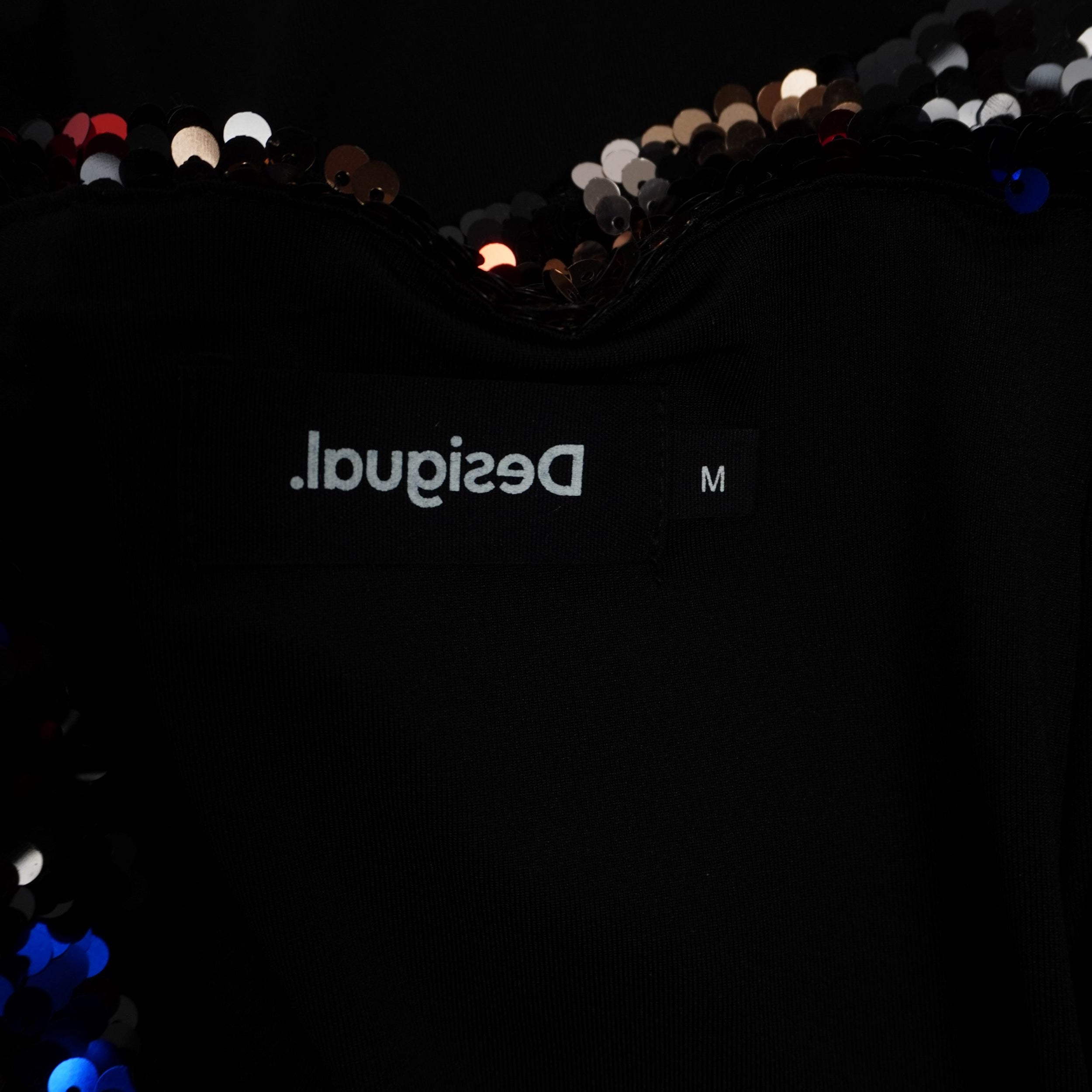 Primo piano del logo Desigual ricamato in filo nero sulla parte posteriore della gonna, dettaglio di autenticità.