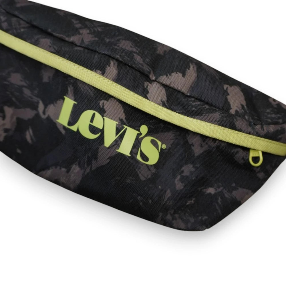 Inquadratura ravvicinata del logo Levi's impresso in giallo lime sul davanti del marsupio streetwear e dettaglio della cerniera coordinata.