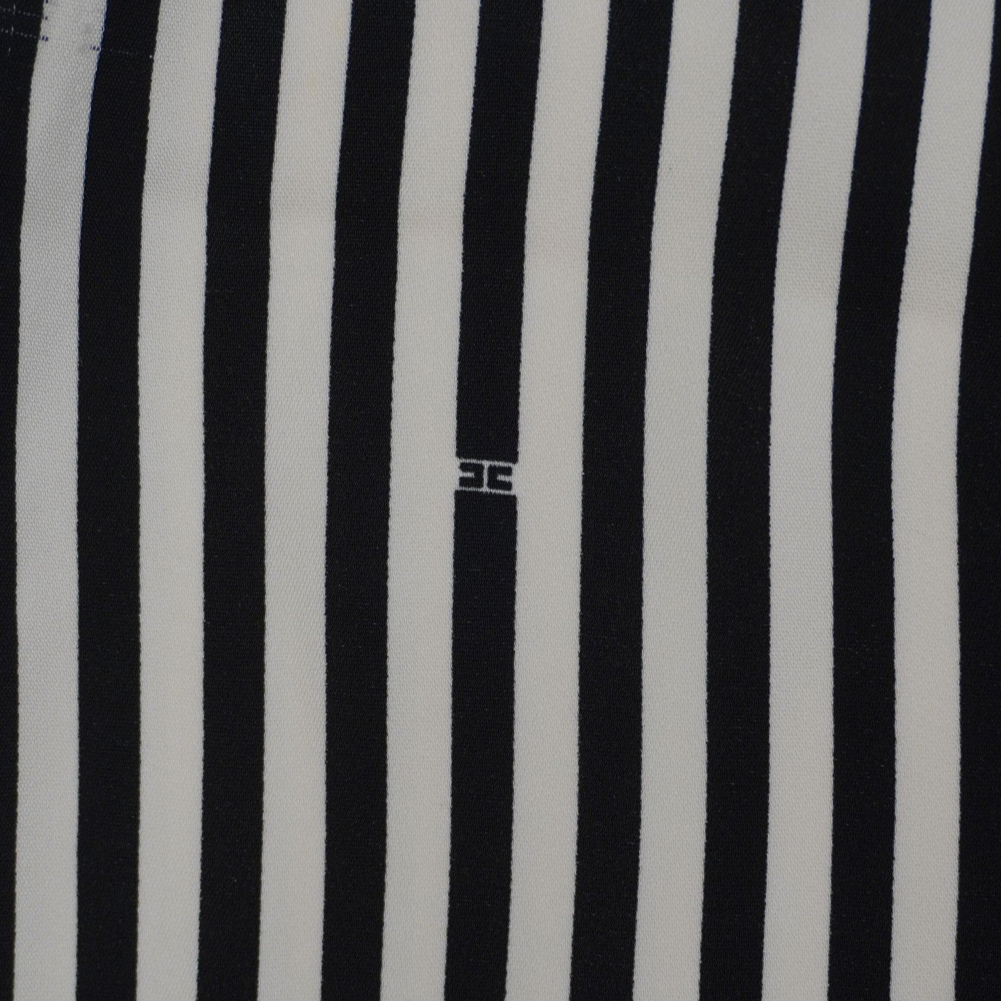 Primo piano del pattern optical a righe con piccolo logo monogram Elisabetta Franchi ricamato tono su tono.