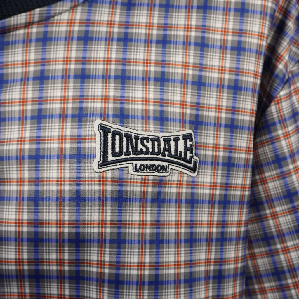 Dettaglio macro logo ricamato Lonsdale London applicato su giacca da uomo a quadri