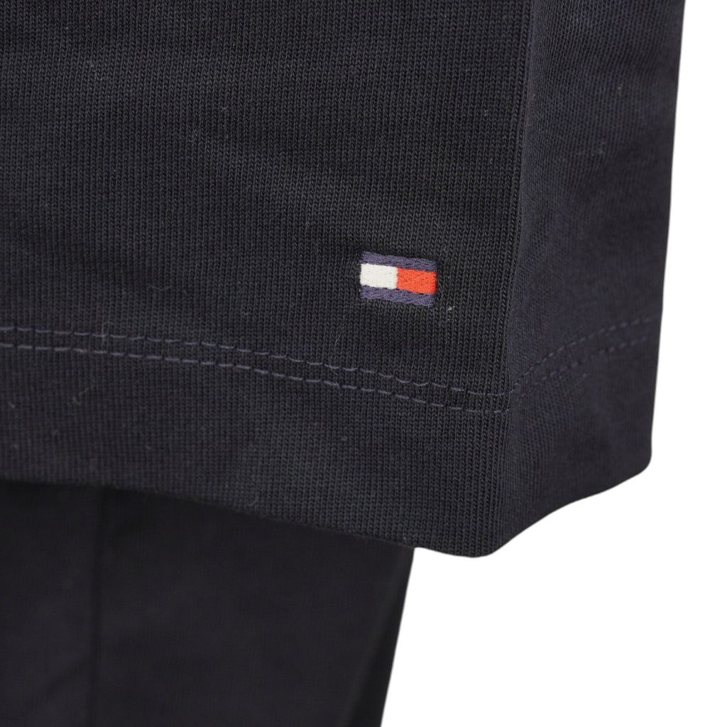 Primo piano dell'iconico mini logo a bandierina flag Tommy Hilfiger ricamato sul bordo della manica sinistra.