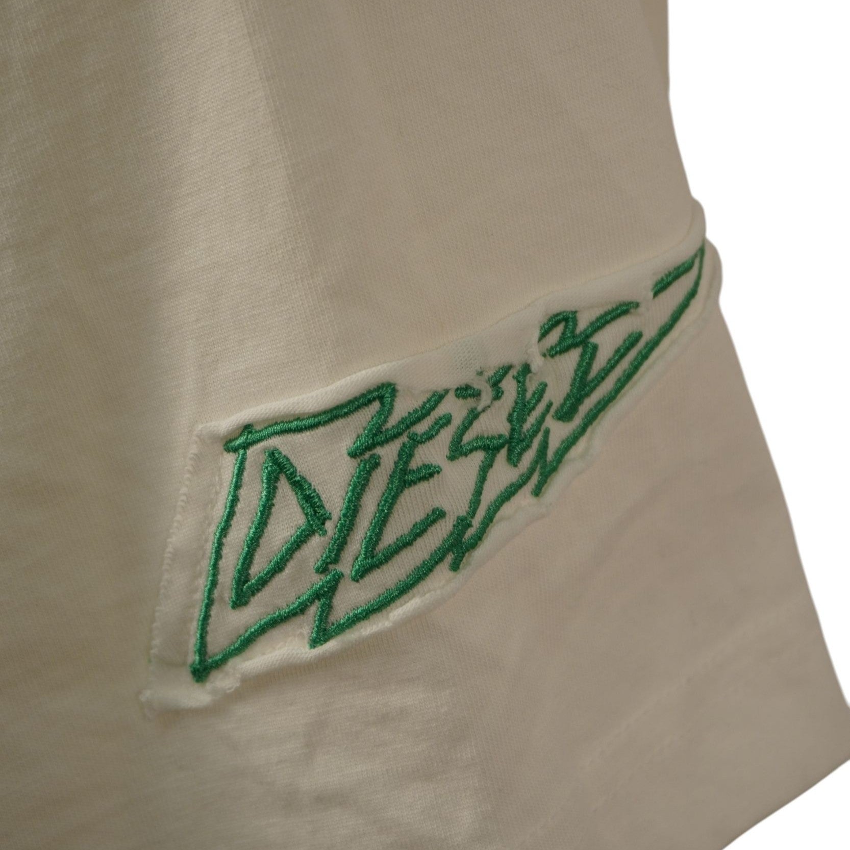 Primo piano del logo Diesel verde stile graffiti stampato sulla manica della T-shirt.