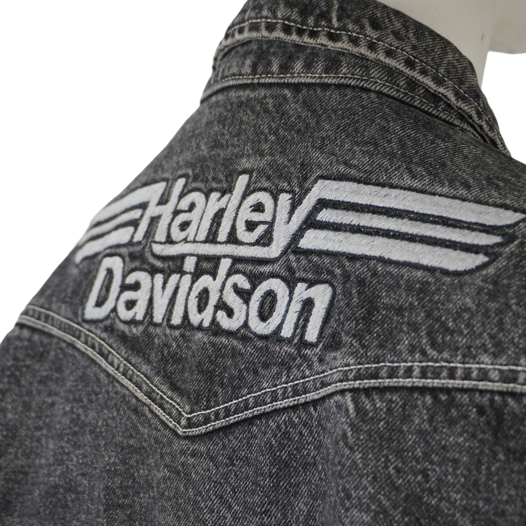  Primo piano macro e laterale del maxi ricamo tridimensionale ad alta densità Harley-Davidson sullo sprone a V della giacca.