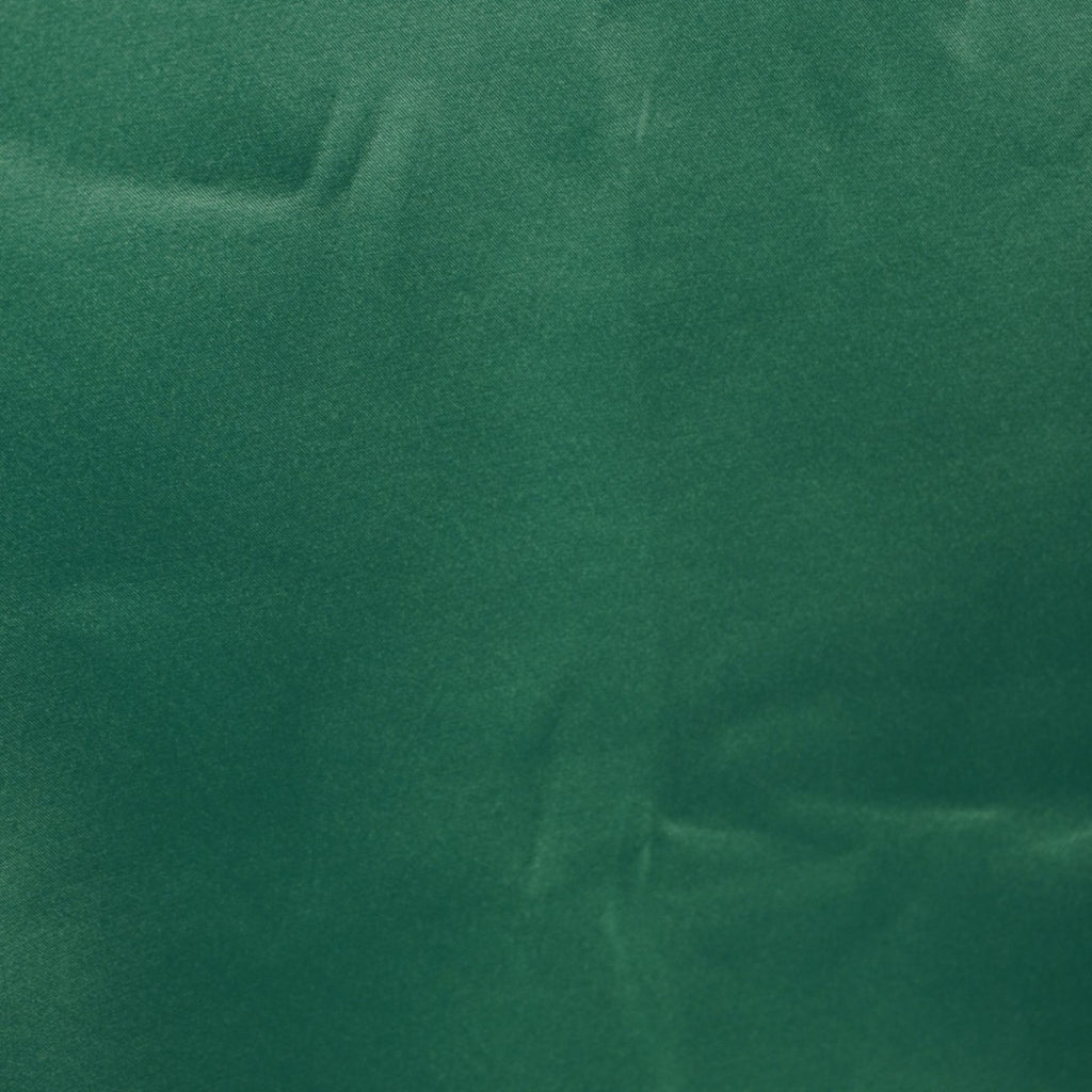 Primo piano della parte inferiore posteriore del vestito verde che mostra la finitura dell'orlo e le impercettibili striature menzionate.