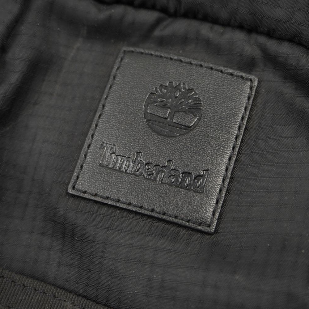 Macro sul logo quadrato Timberland con l'albero e la scritta impressi a rilievo tono su tono.