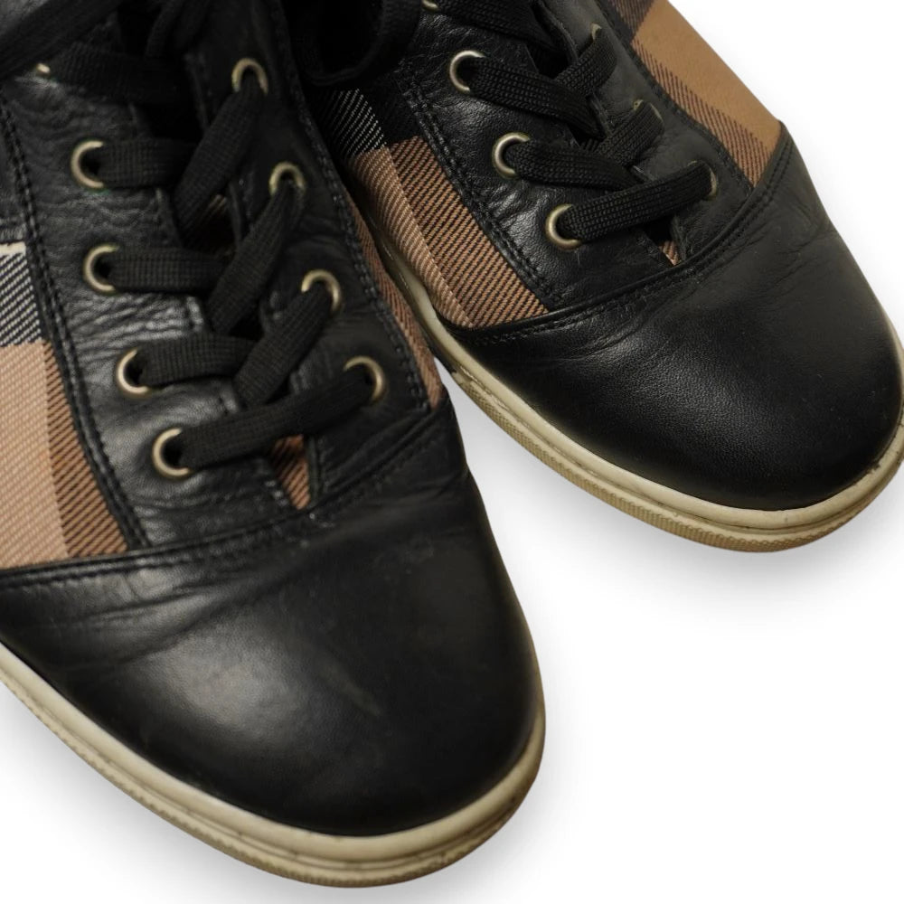 Primo piano della punta in pelle nera e dei lacci delle sneakers alte Burberry
