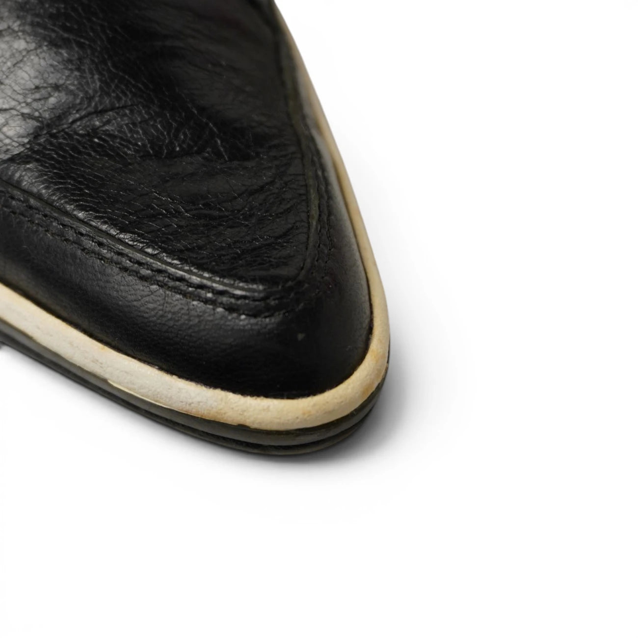 Dettaglio macro punta affusolata in pelle nera e suola ingiallita sneaker Puma x Alexander McQueen
