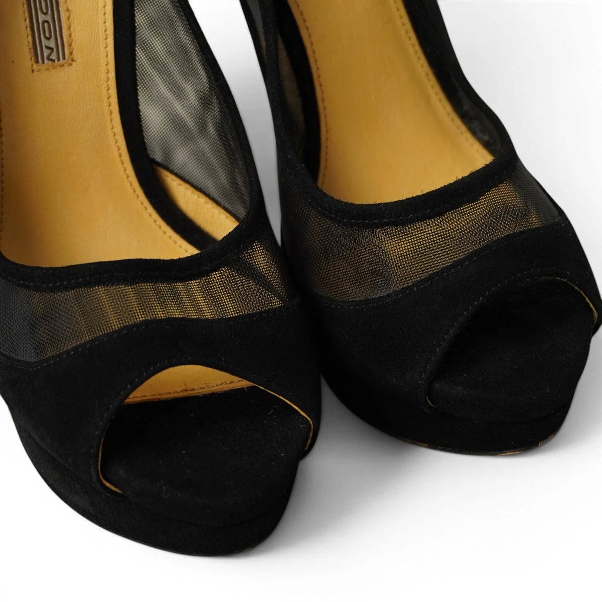 Primo piano ravvicinato della punta aperta peep toe e della trama in tessuto mesh nero trasparente delle scarpe Buffalo London.