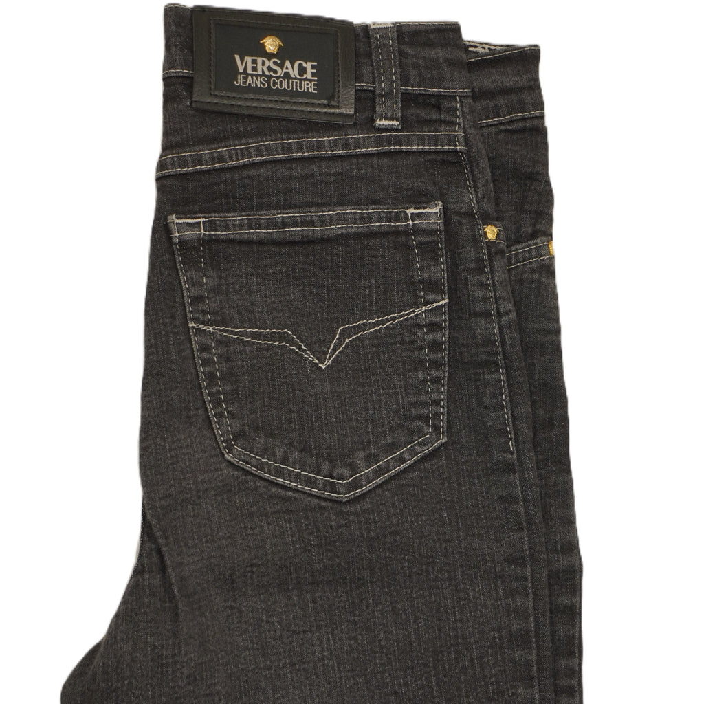 Inquadratura ravvicinata del retro dei jeans con focus sulla tasca posteriore destra sagomata e la patch in vita.