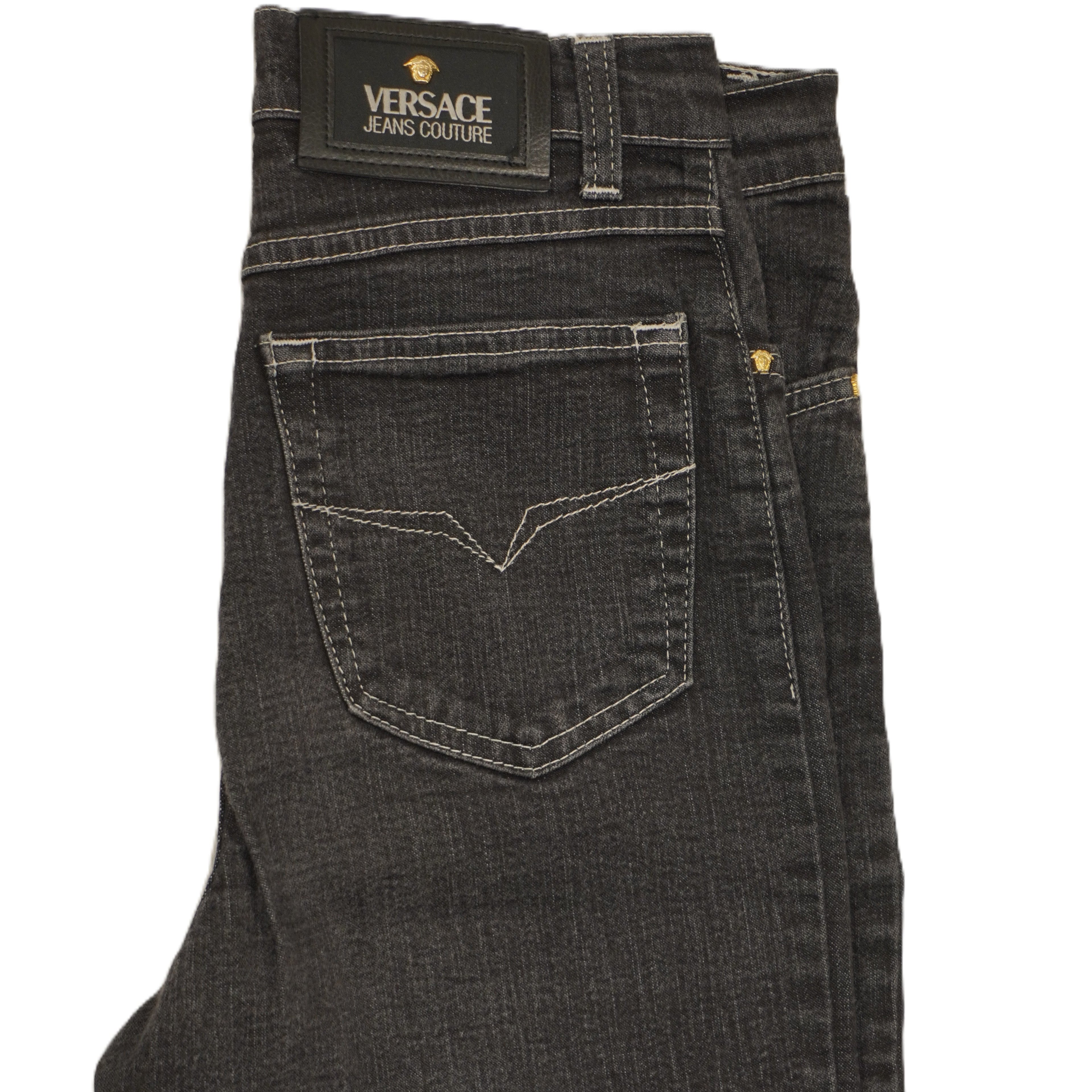 Inquadratura ravvicinata del retro dei jeans con focus sulla tasca posteriore destra sagomata e la patch in vita.