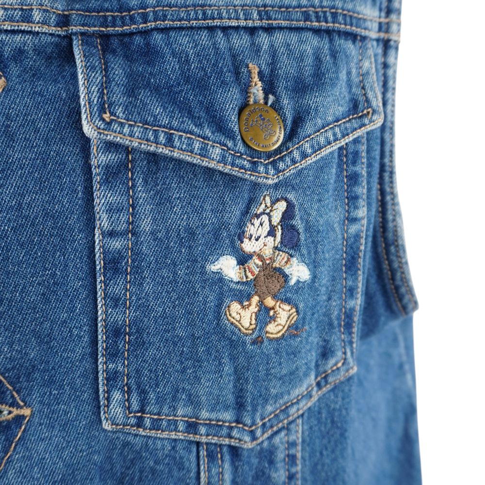 Primo piano della tasca anteriore del gilet in jeans con ricamo originale a colori di Minni Mouse in stile escursionismo.