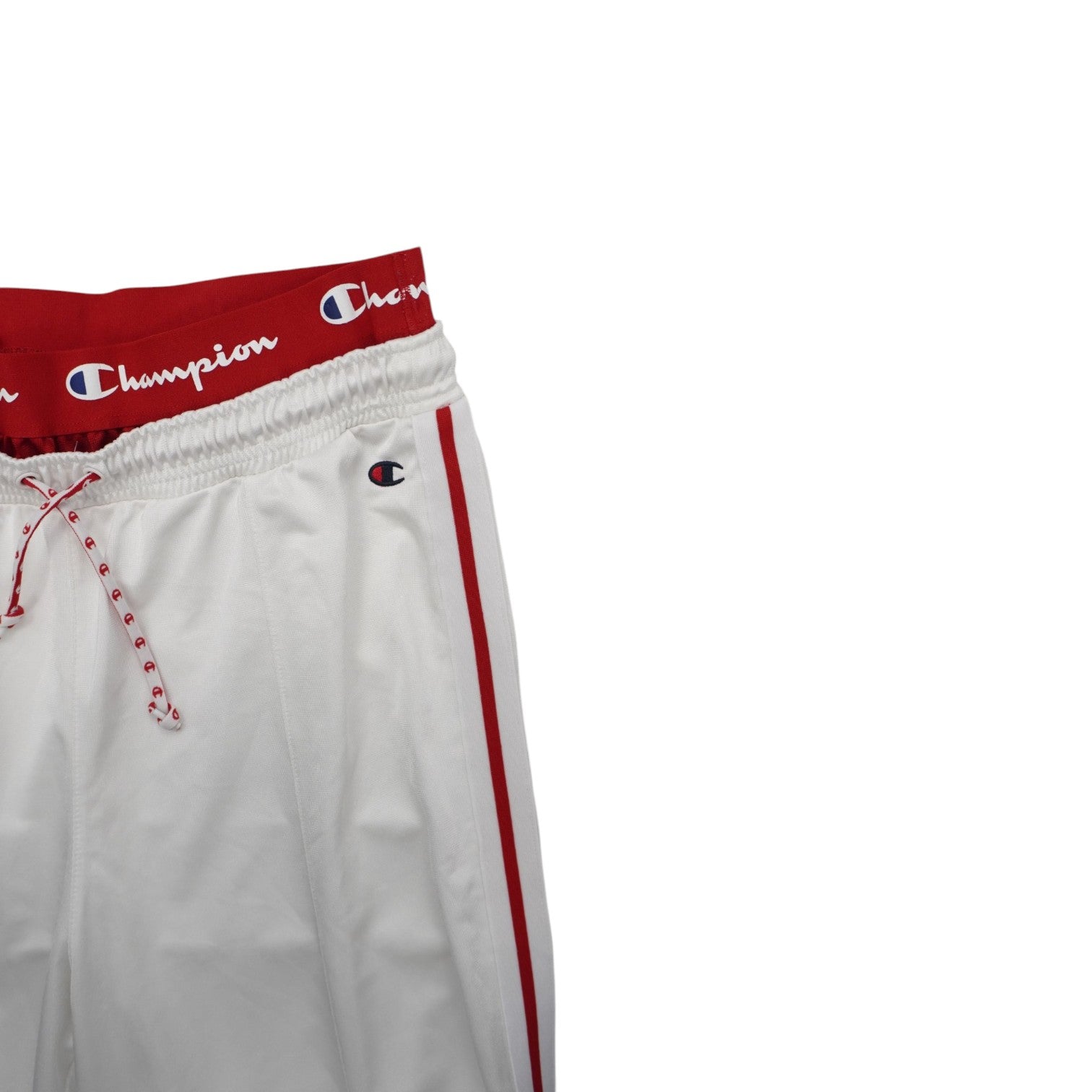 Primo piano della gamba del pantalone con doppie righe rosse laterali su tessuto tecnico bianco satinato.